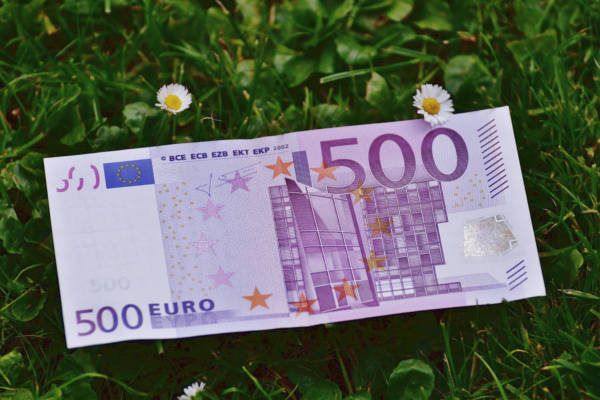 500-Euro-Schein im Gras mit Gänseblümchen