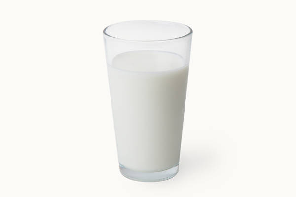 Glas mit frischer Milch auf weißem Hintergrund