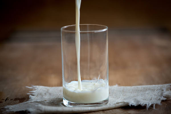 Milch wird in ein Glas gegossen